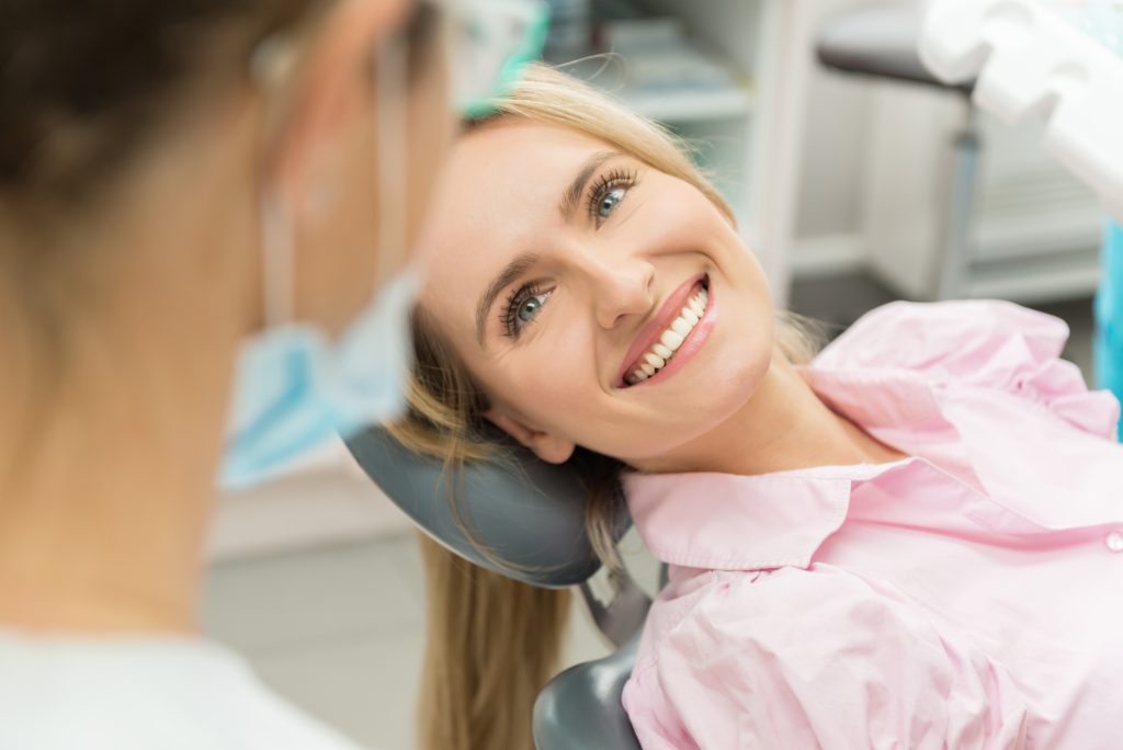 Patient smiling during a dental visit while considering cosmetic dental options